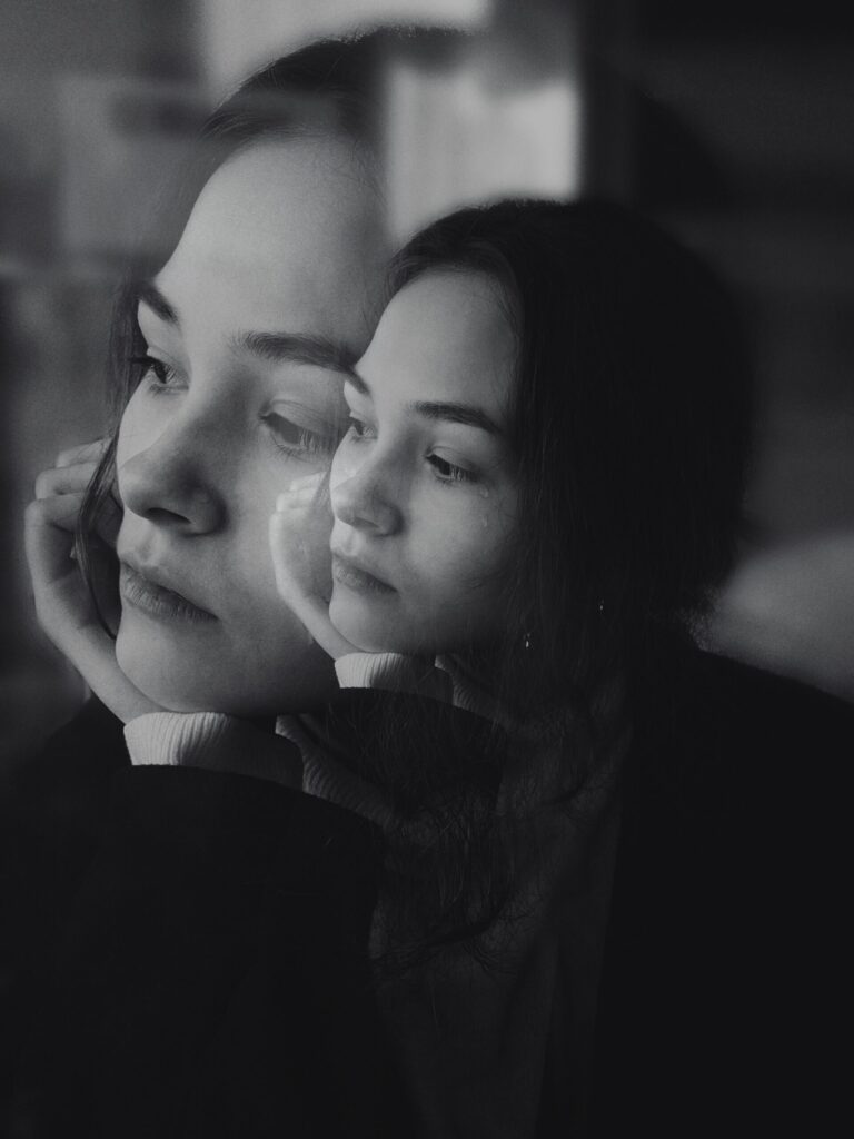 A girl's face with her reflection in black and white from Pexels.