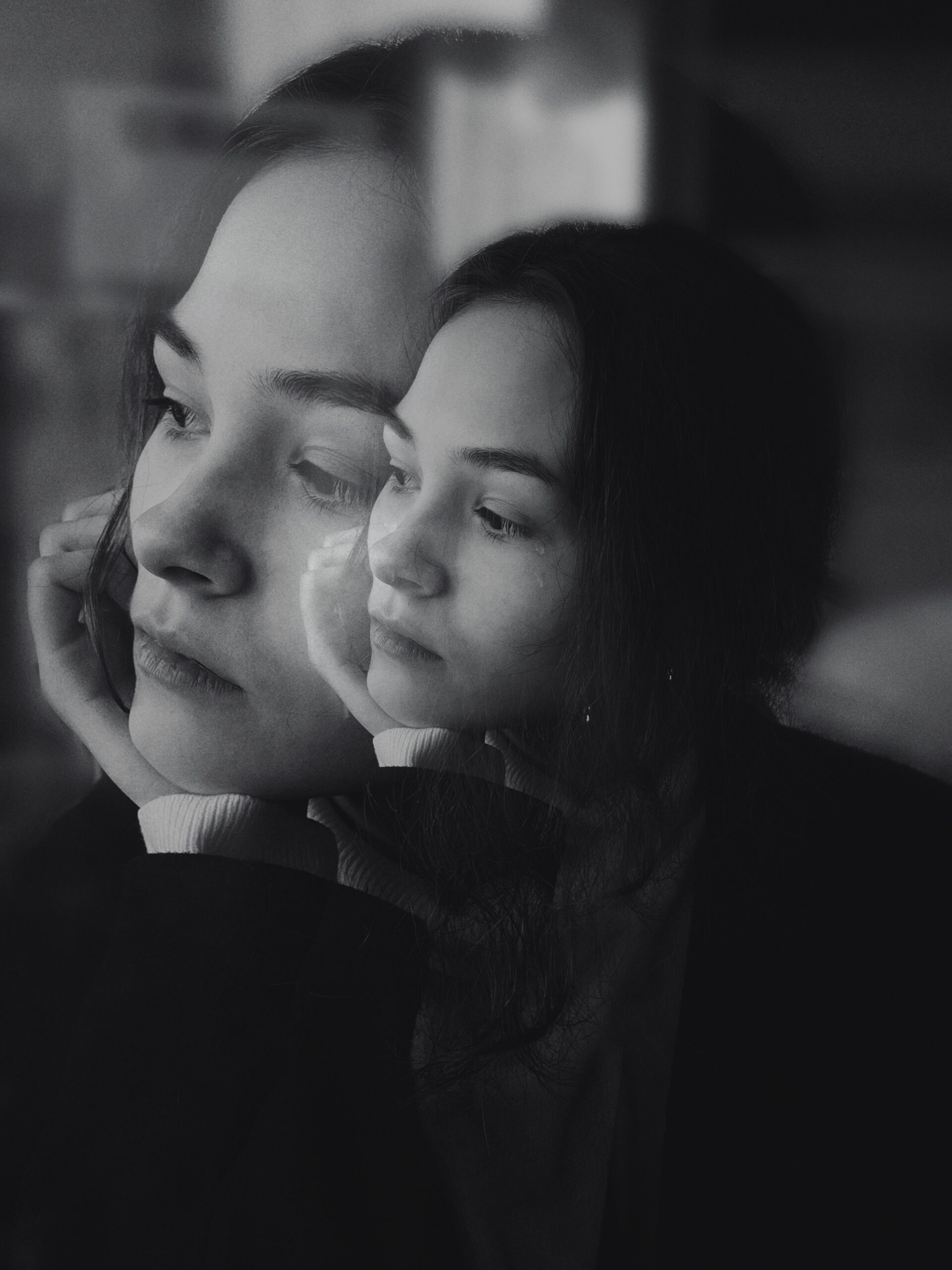 A girl's face with her reflection in black and white from Pexels.