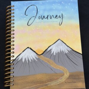 Planner with the blue sky, warm yellow sun, snow capped mountains, and a girl on a girl with a pink backpack walking on a road.